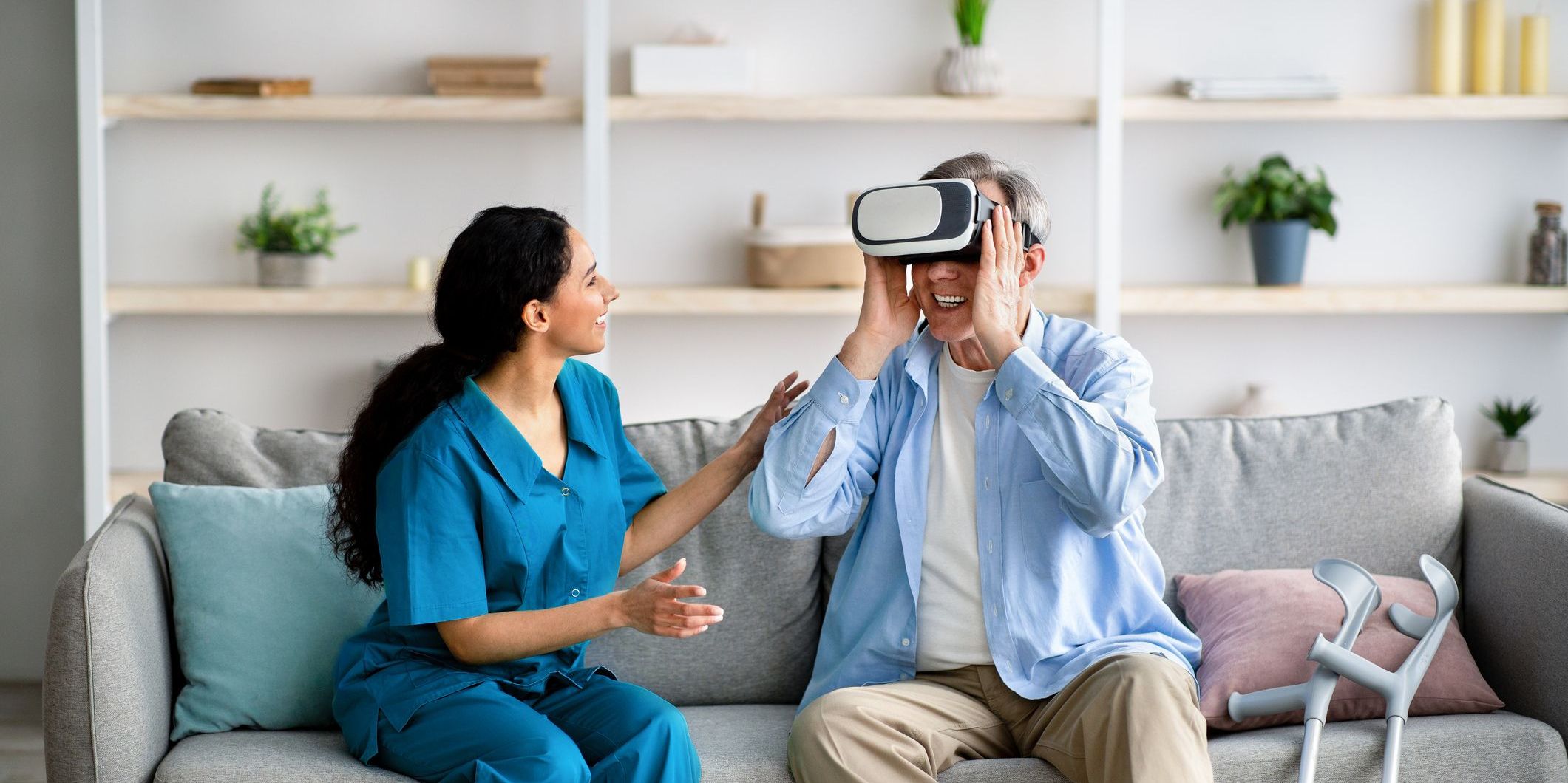 A person wearing a VR headset being assisted by a young medical professional