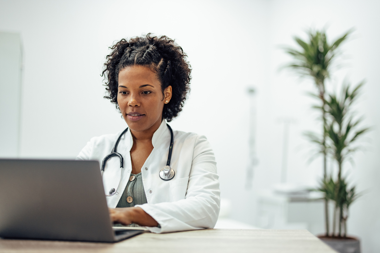 Healthcare professional working at a laptop