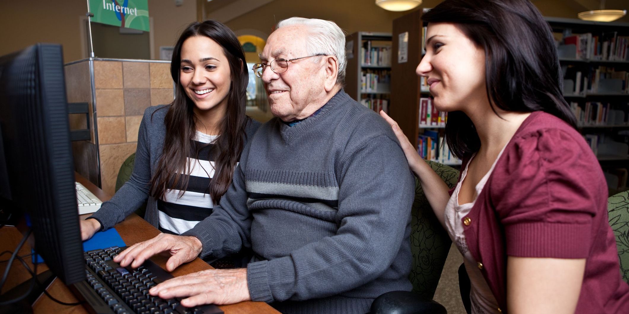 Two women and an older man looking at a computer