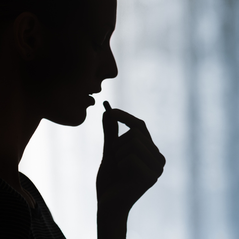 Silhouette of someone taking a tablet