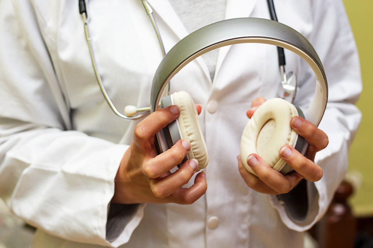 A healthcare professional holding headphones