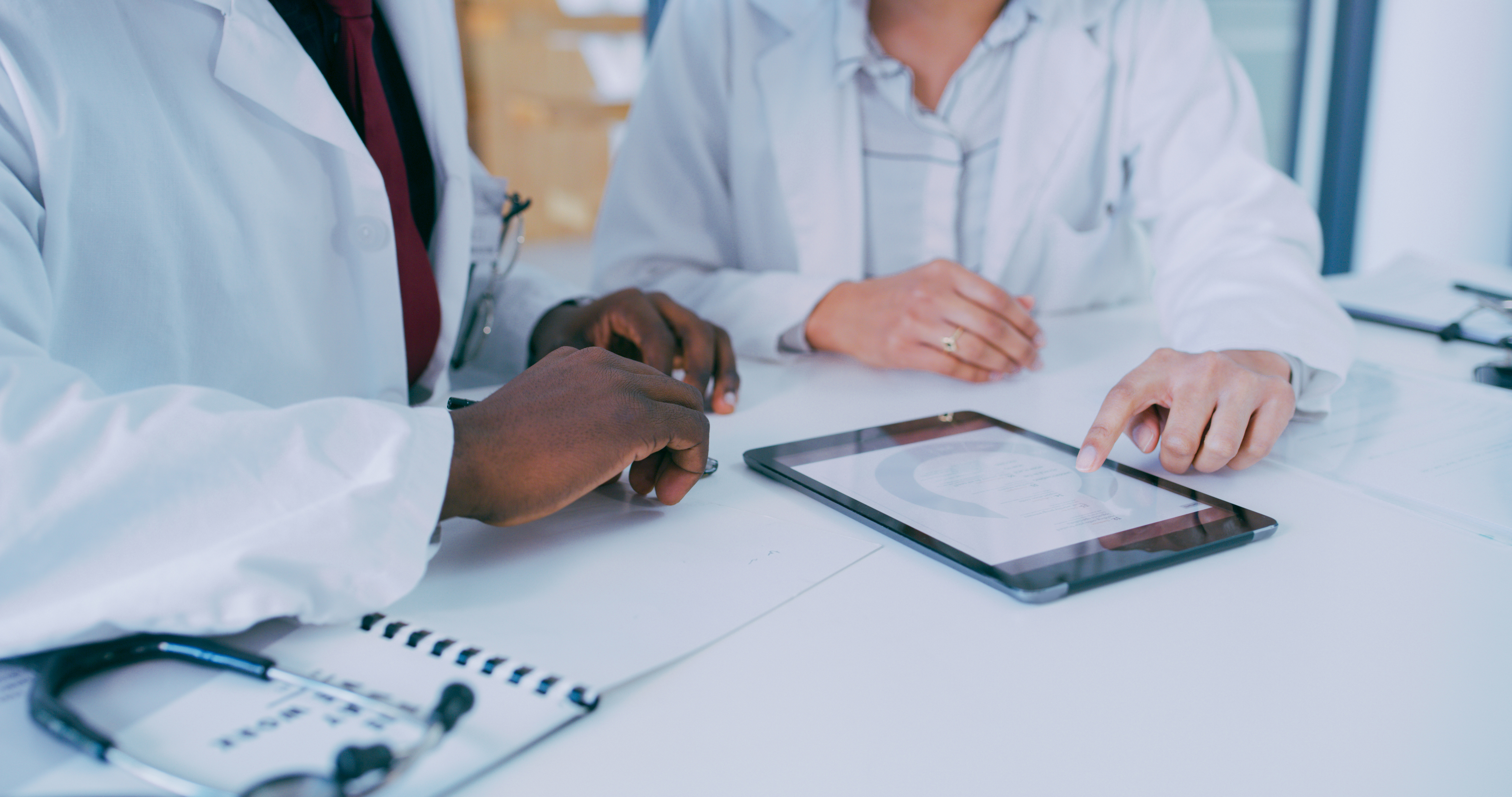 Two healthcare professionals looking at a digital tablet