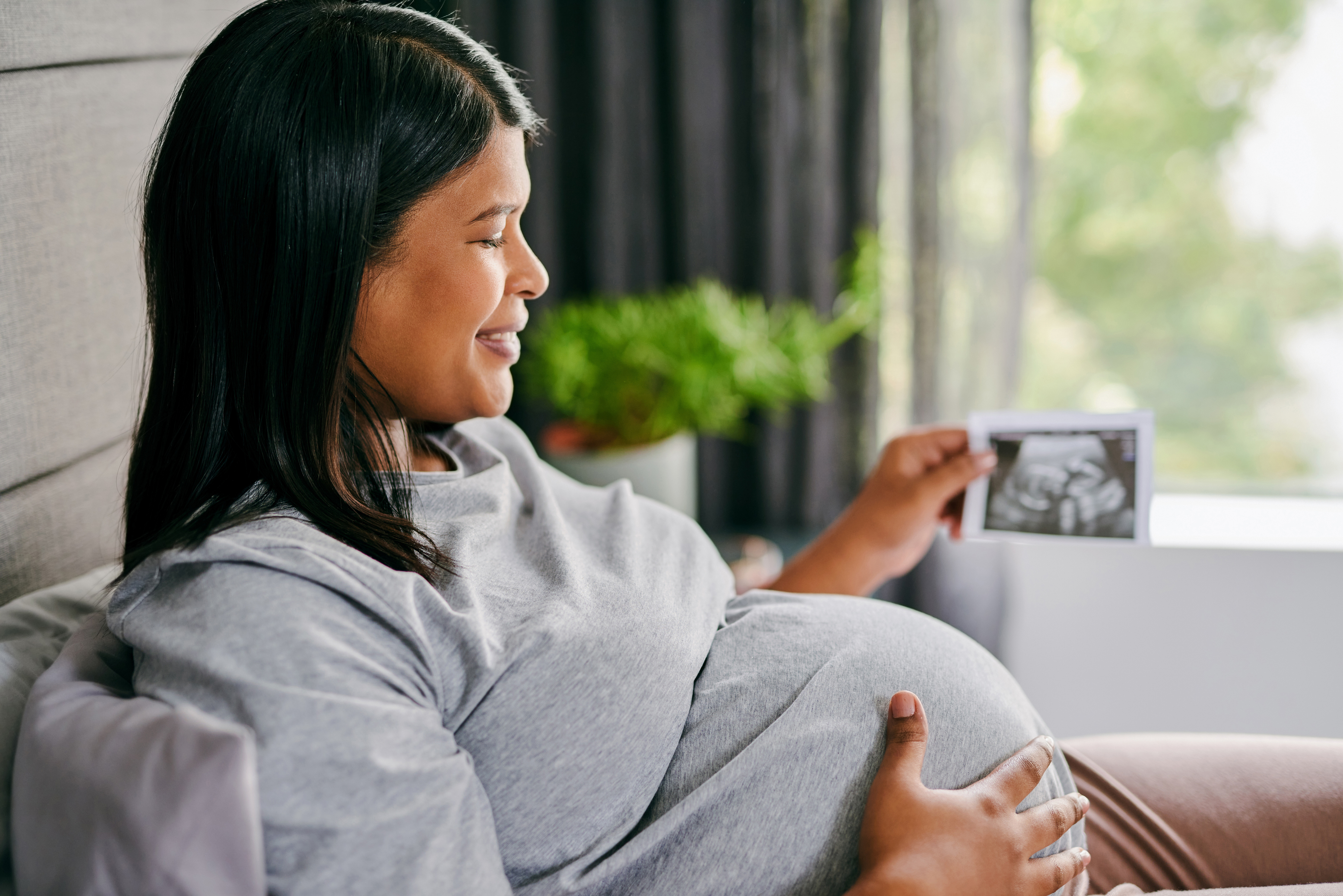 Pregnant woman looking at a print out of her scan