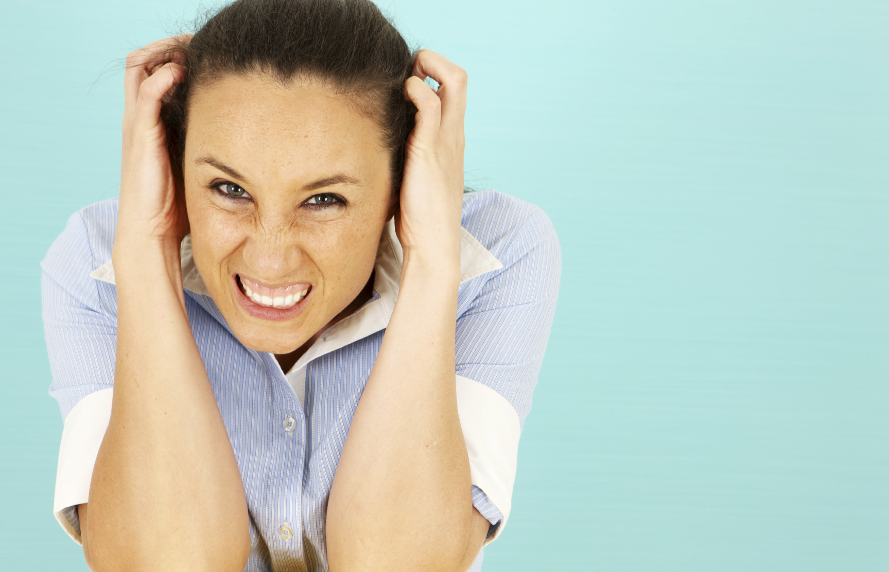 A healthcare professional clutching her head, she looks angry