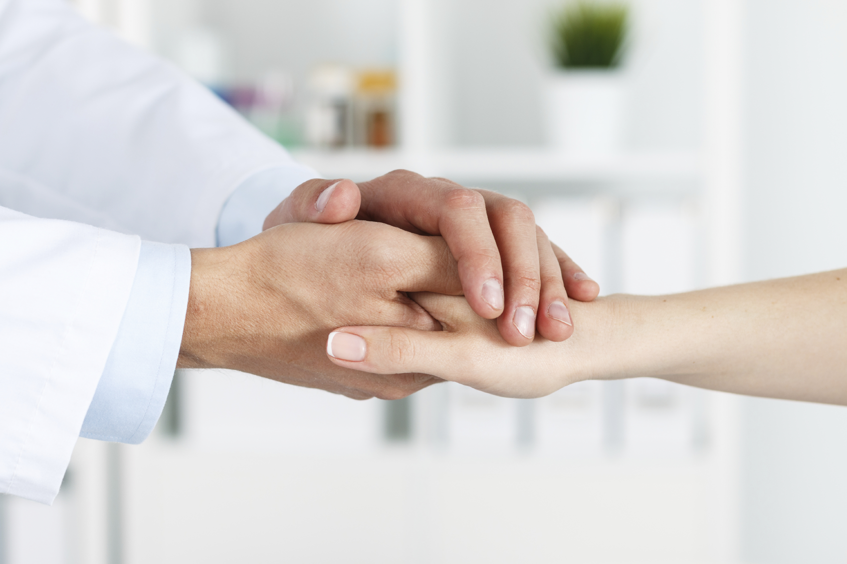 Healthcare professional holding the hand of with a patient