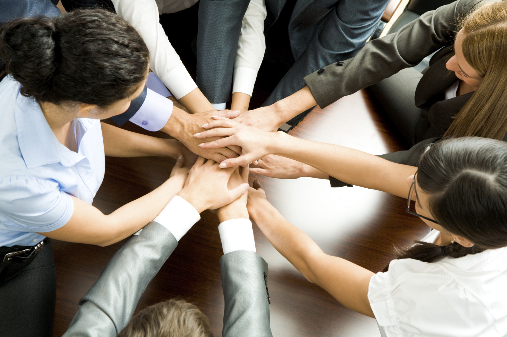A group of people with their hands in the centre