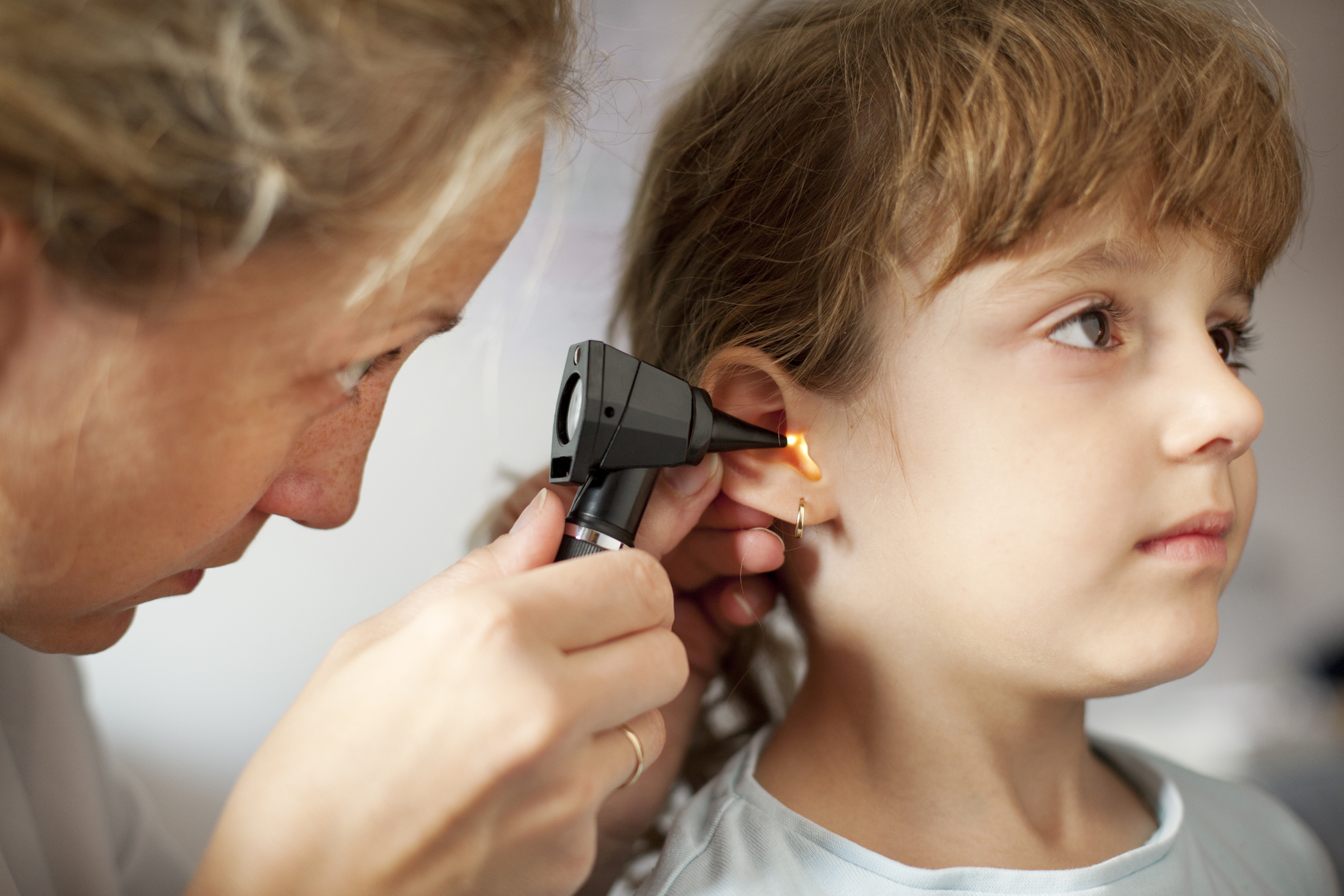 A healthcare professional examining a child's ear