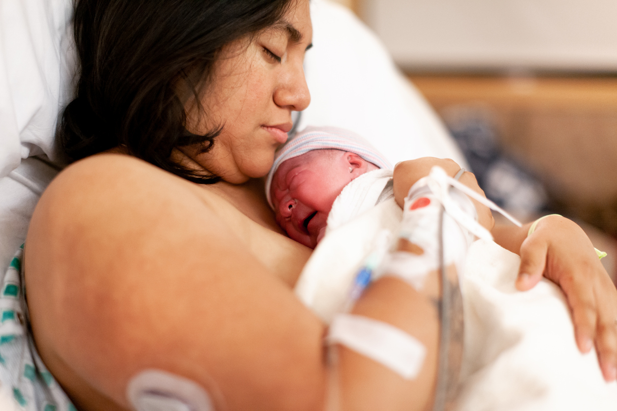 A mother holding a baby to her chest