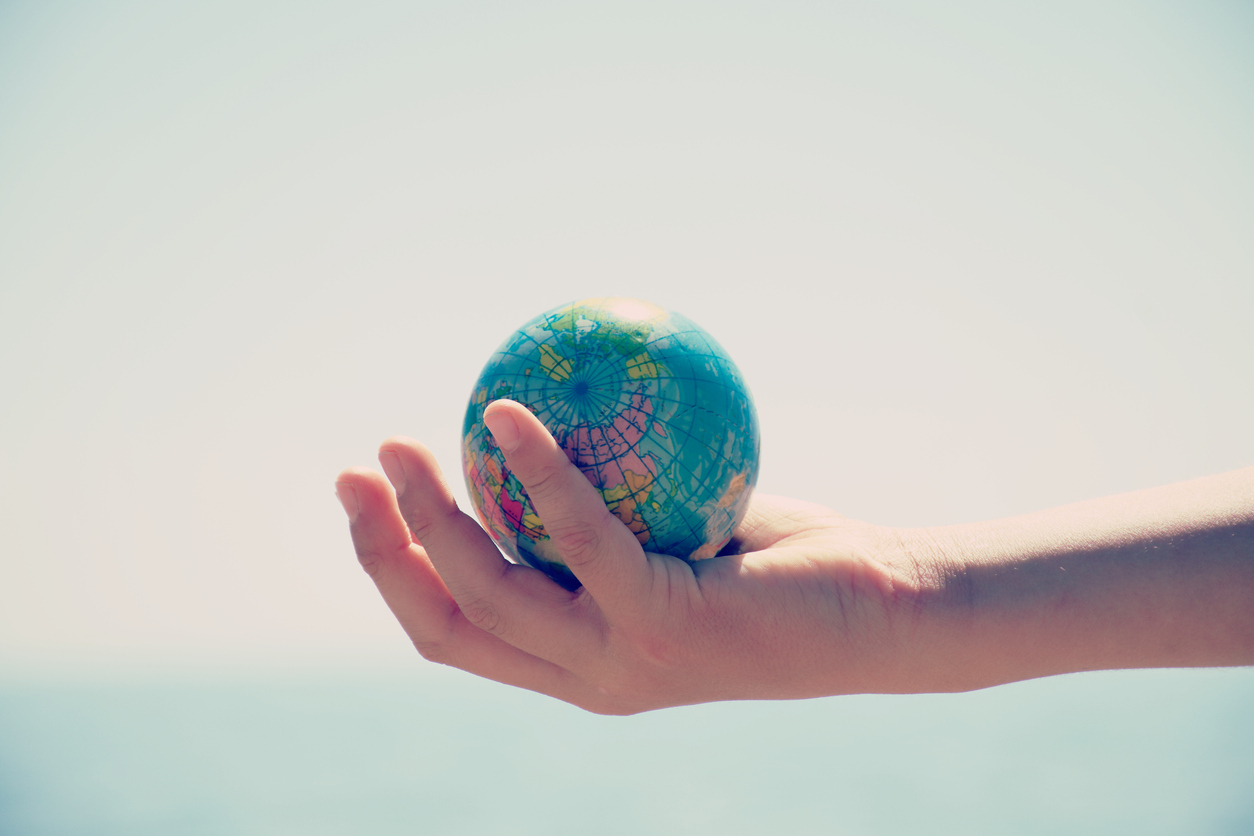 a hand holding a small globe