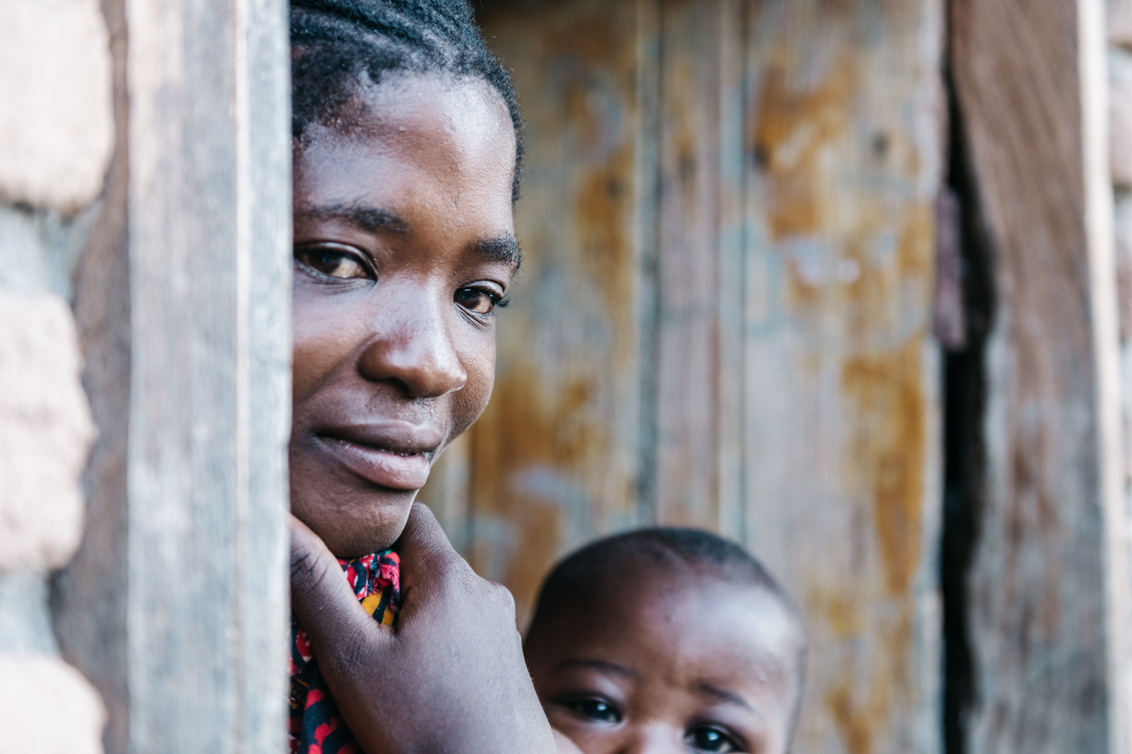 A mother and a baby standing in a doorway